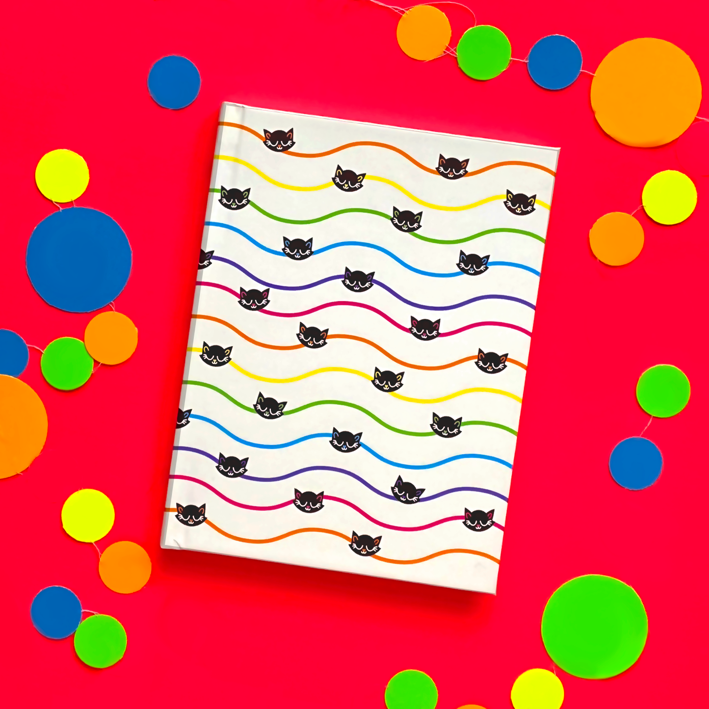 White journal with wavy rainbow pinstripes and black cats